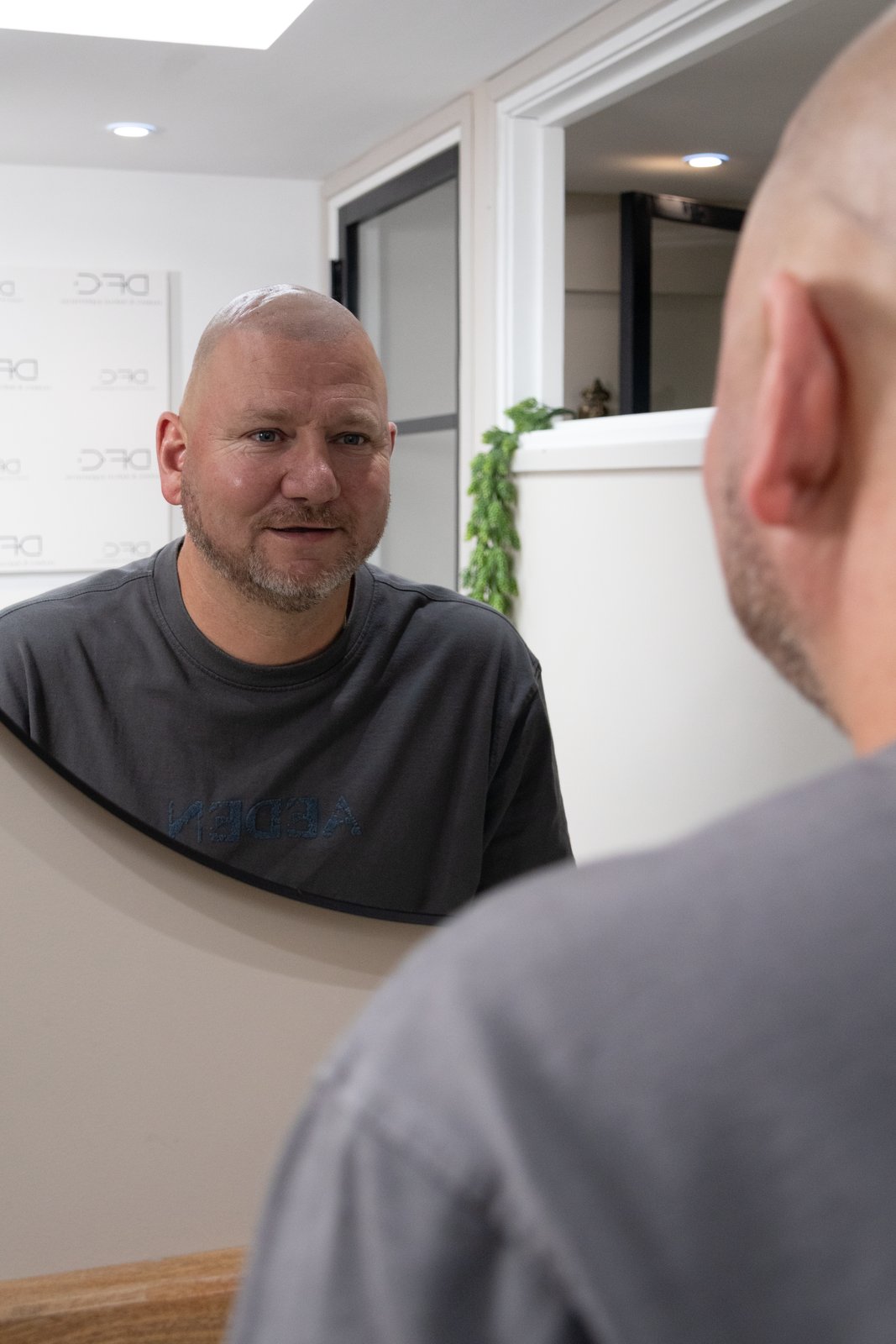 Resultaat Micro Haar Pigmentatie in de spiegel Klant bekijkt in de spiegel het resultaat van Micro Haar Pigmentatie bij DFine Clinic
